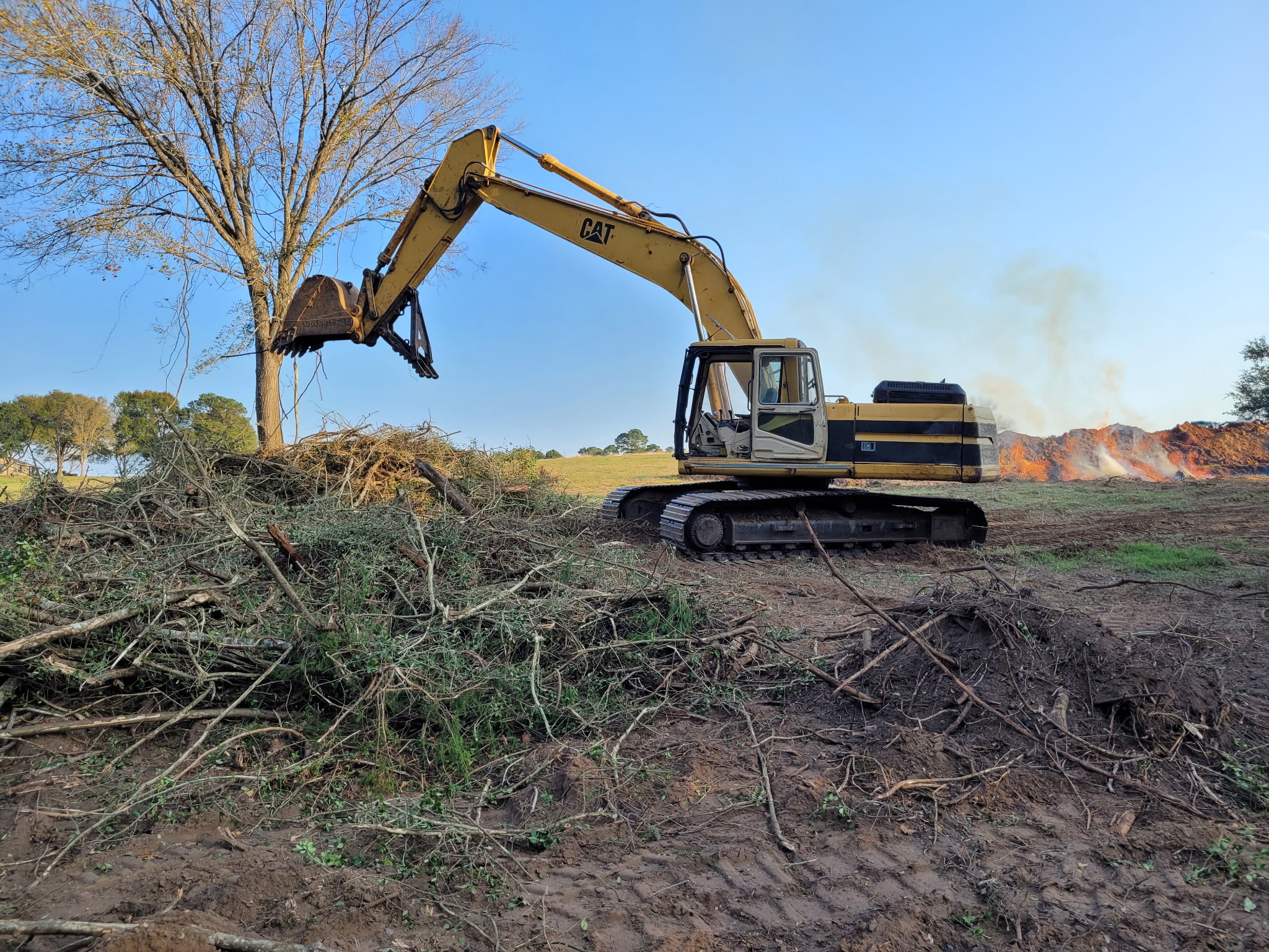 Crew finishing debris cleanup on a land clearing project